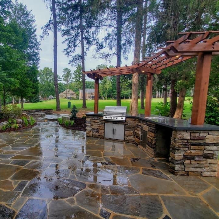 Stone outdoor kitchen beneath a timber pergola