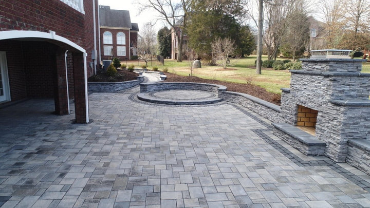 Expansive paver patio with stone fireplace